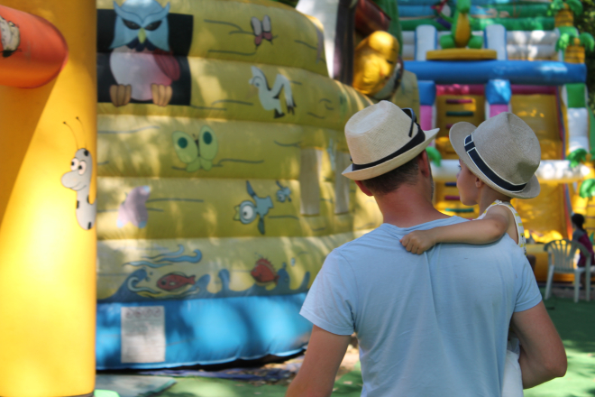 Un papa et son enfant à bord d'un jeu gonflable