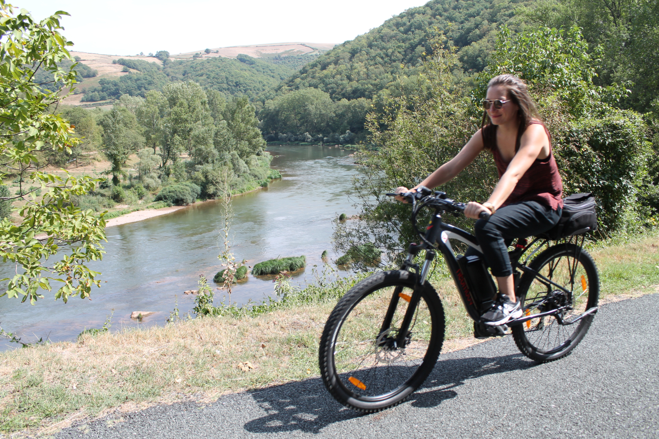 Femme faisant une balade à vélo électrique au bord du Tarn