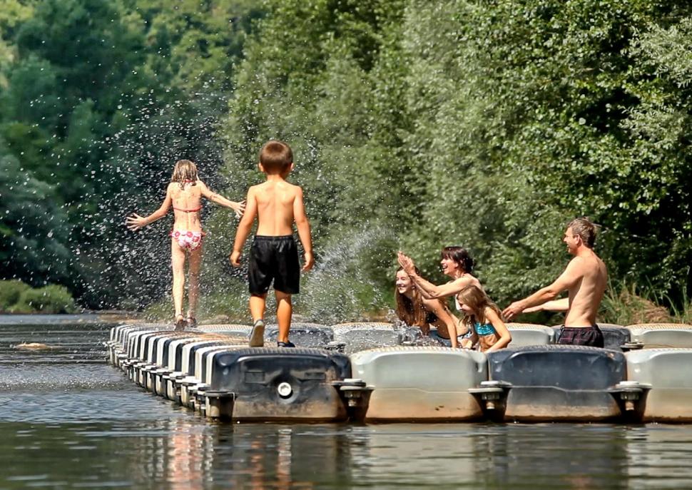 Famille qui joue dans l'eau à la base de loisir de Trébas-les-Bains